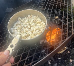 Popcorn till barnen på fjälltur, tillagas över öppen eld i ett trangiakök