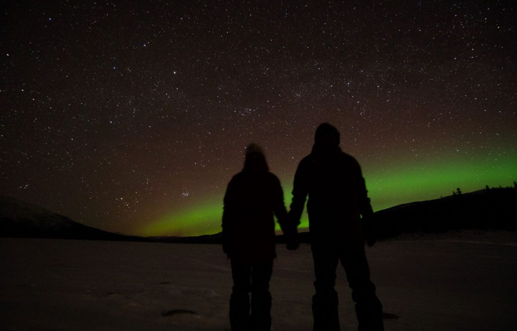 Personer som tittar på vackert norrsken i Borgafjäll