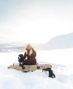 Person som fixar med snowboarden i vinterlandskap